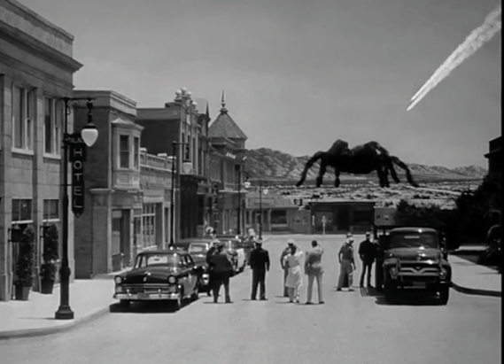 Un grupo de personas observa desde una calle de un pueblo antiguo un enorme arácnido que se encuentra en el horizonte bajo un cielo despejado con una estela de avión.

Description generated by AI
