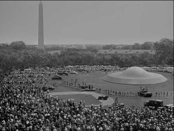 Multitud de personas reunidas alrededor de una estructura circular con cúpula en un parque con el Monumento a Washington visible al fondo.

Description generated by AI