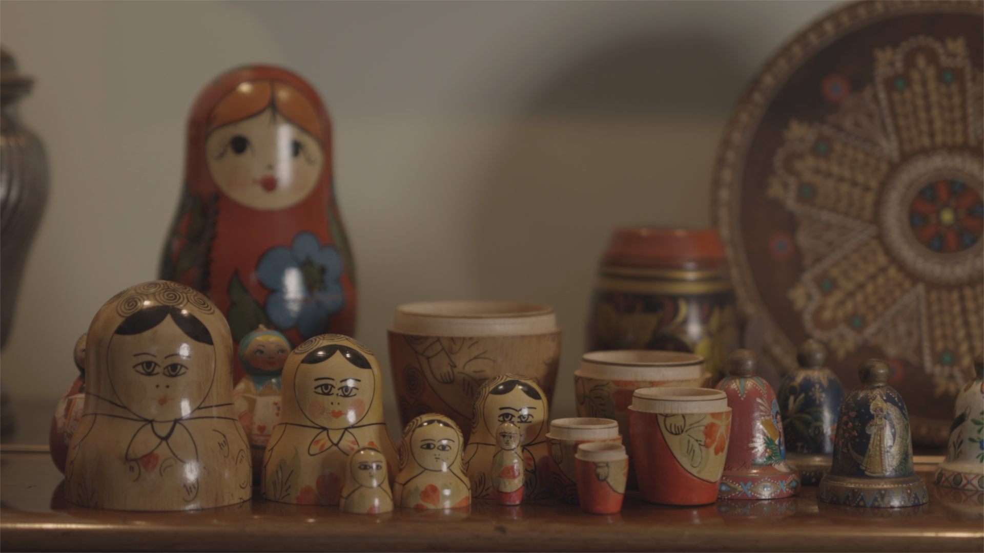 Conjunto de muñecas rusas de madera pintadas a mano de diferentes tamaños colocadas sobre una superficie de madera con un fondo desenfocado.

Description generated by AI