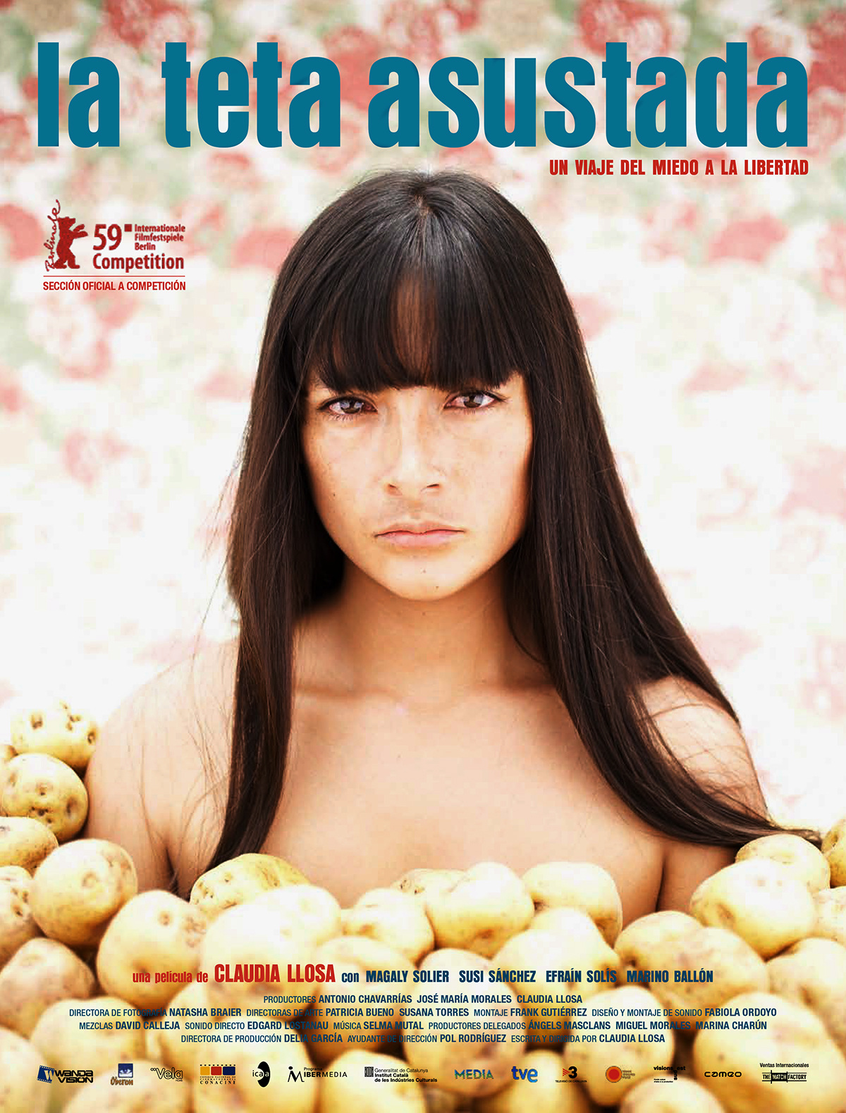 Persona con cabello largo y lacio mirando fijamente mientras está rodeada de papas, con un fondo floral y texto en azul y rojo que indica el título "la teta asustada" y detalles de una competencia cinematográfica.

Description generated by AI